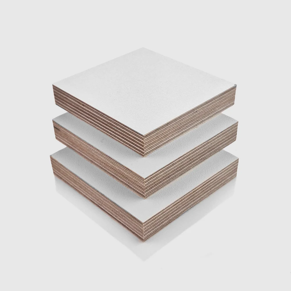 18mm White PP Faced Plywood (WISA Multiwall – Textured) 18mm White PP Faced Plywood (WISA Multiwall) sheets stacked on top of each other, in an orderly arrangement.