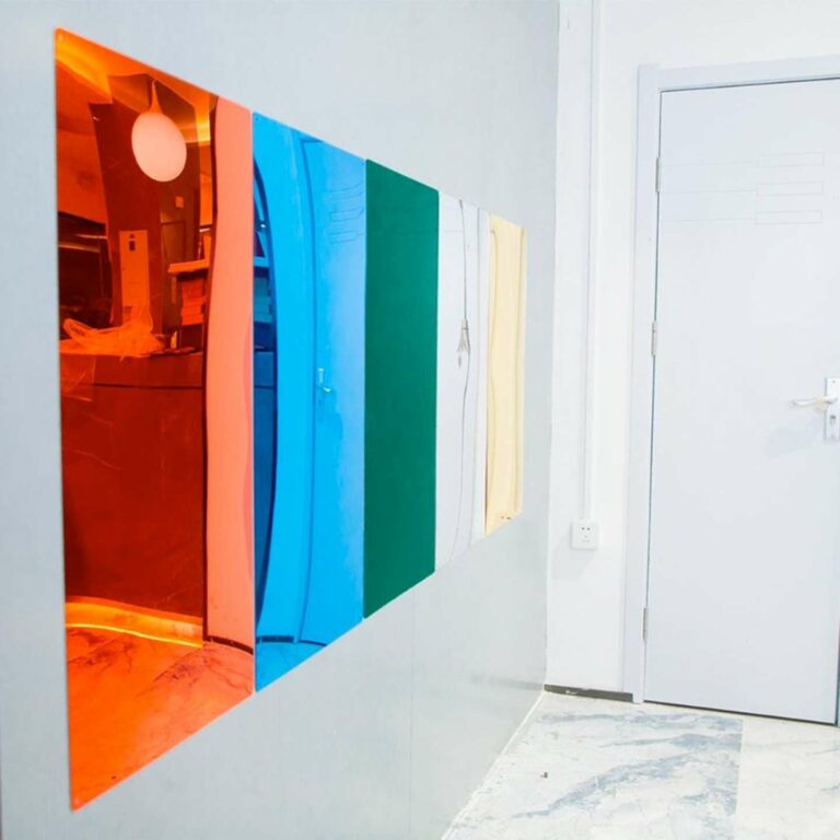 Coloured mirrored sheets on a wall.