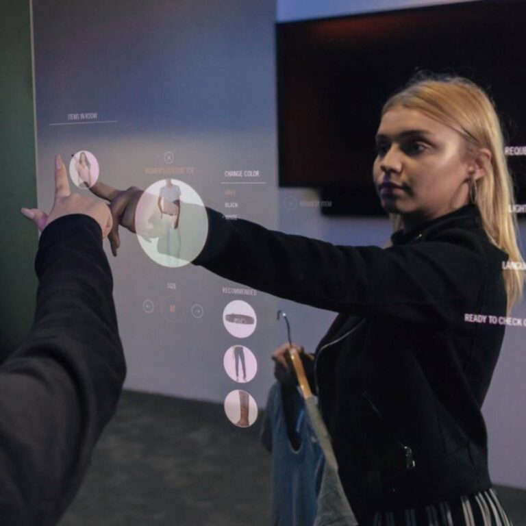A woman using a two way mirror with digital technology.