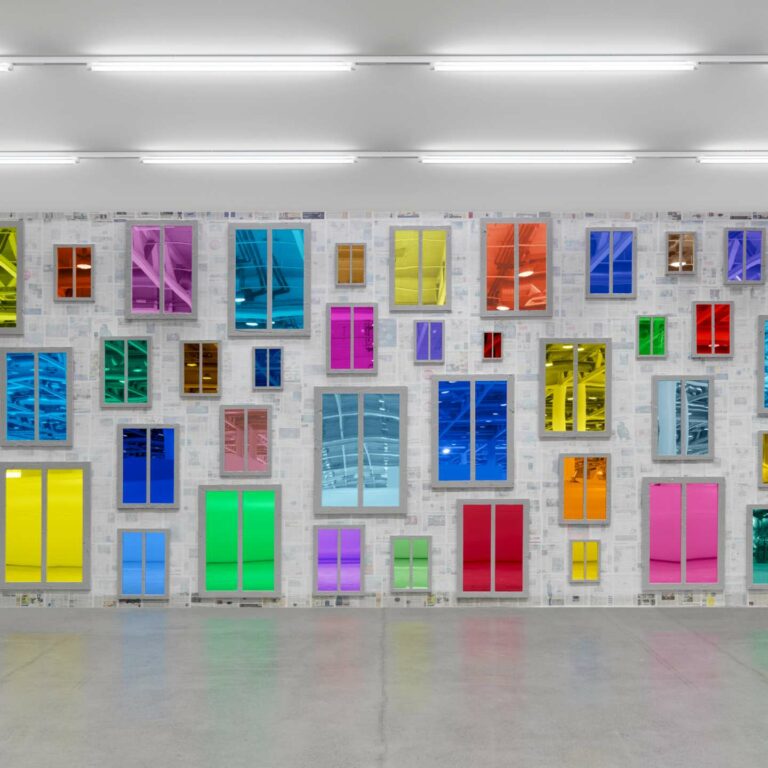 An exhibition display wall with colourful mirrored windows.