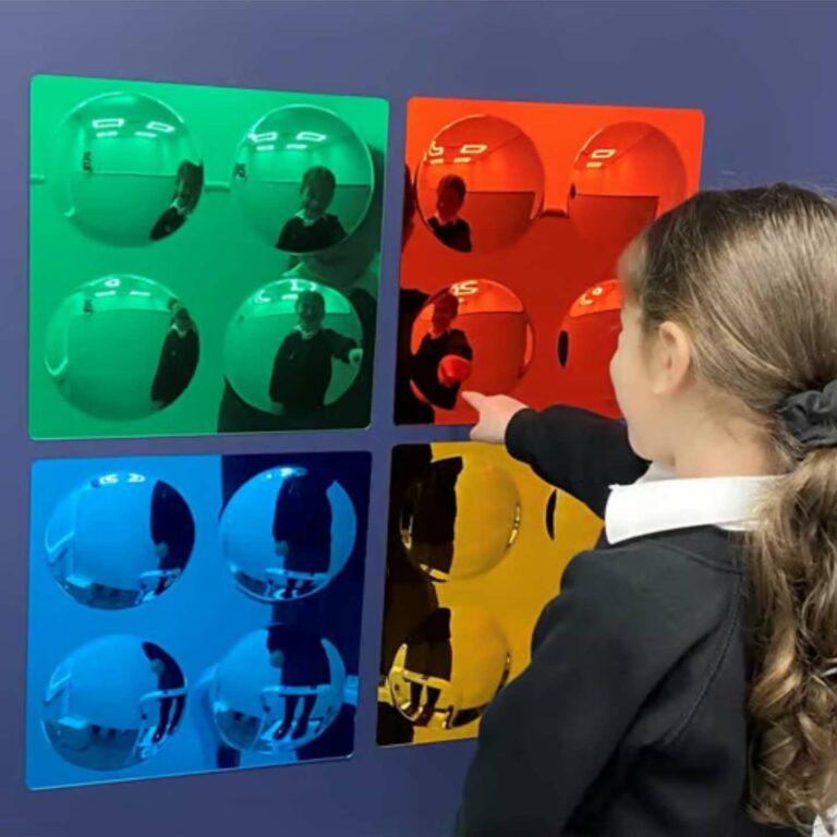 A child playing pointing at different coloured mirrored wall sheets.