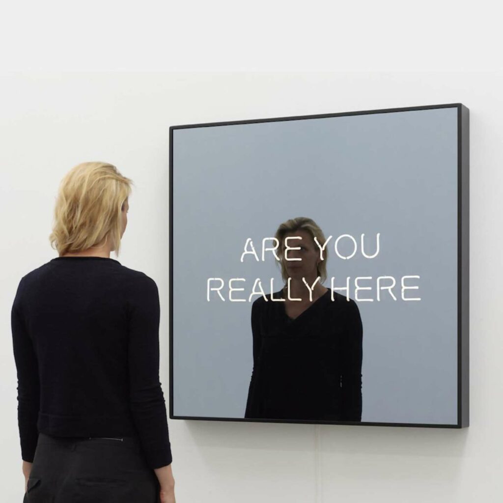 An exhibition two way mirror reading "are you really here".