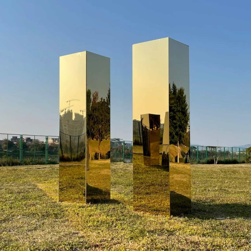 Some gold mirrored plinths outside.