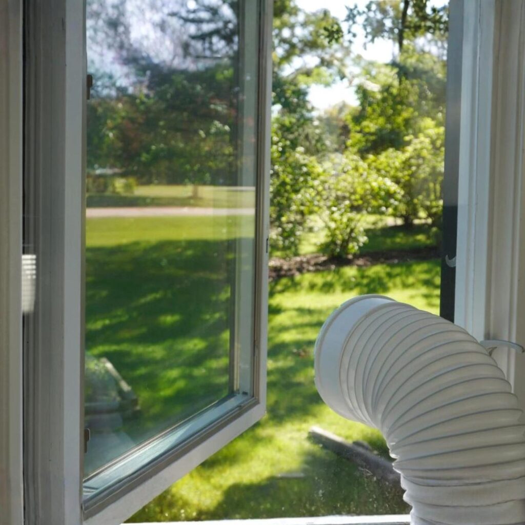 An acrylic AC window seal panel with a sunny outside setting behind.