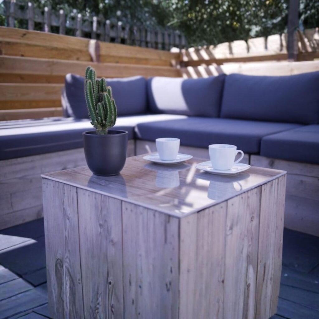 A small outside table with a large sofa behind.
